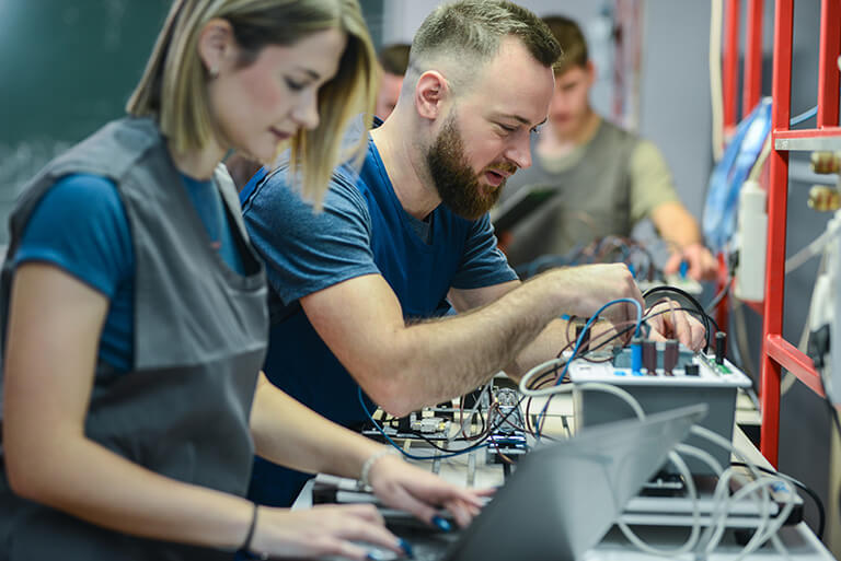 man and woman repairing consumer electronics