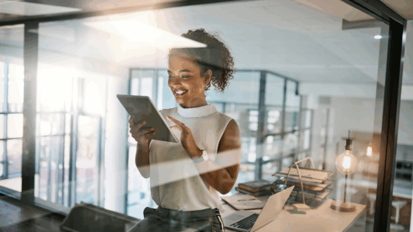 female working in an office, looking at her tablet