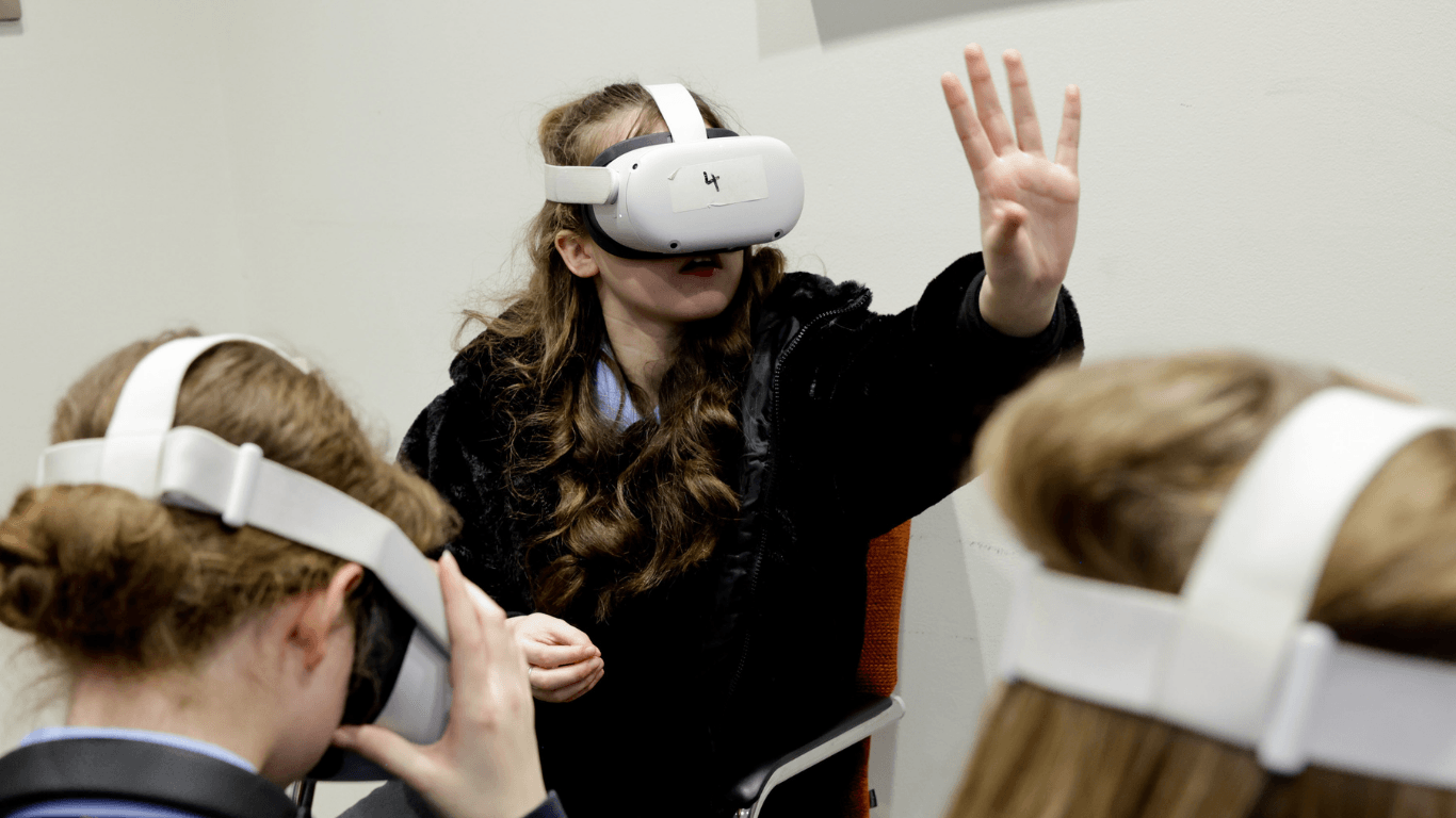 A student trying a virtual reality headset at a FIT school event
