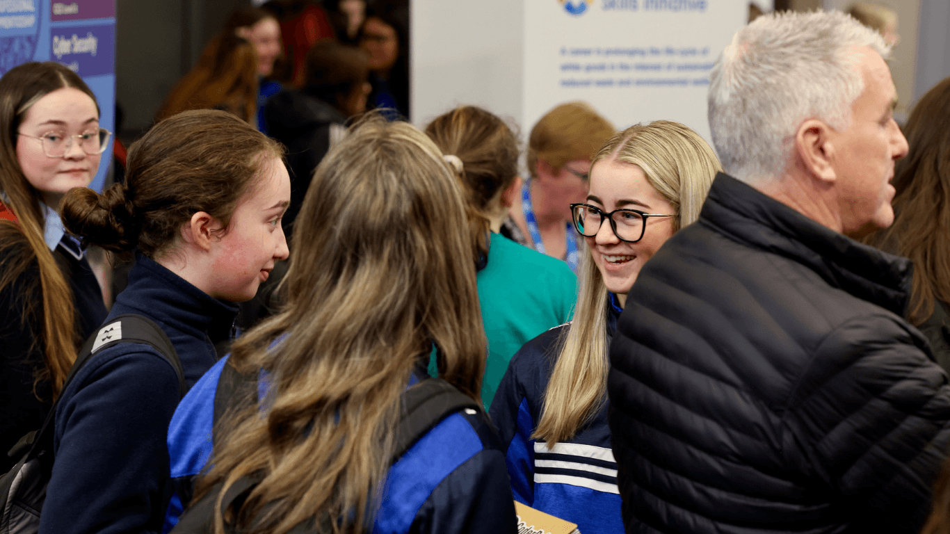 Students talking with an exhibitor at a FIT technology careers event